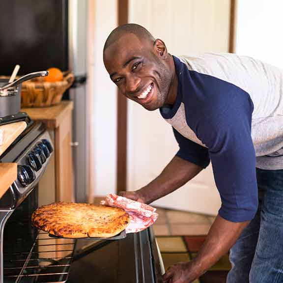 Woman in apron opening oven door