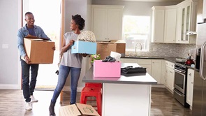 couple moving boxes into new home