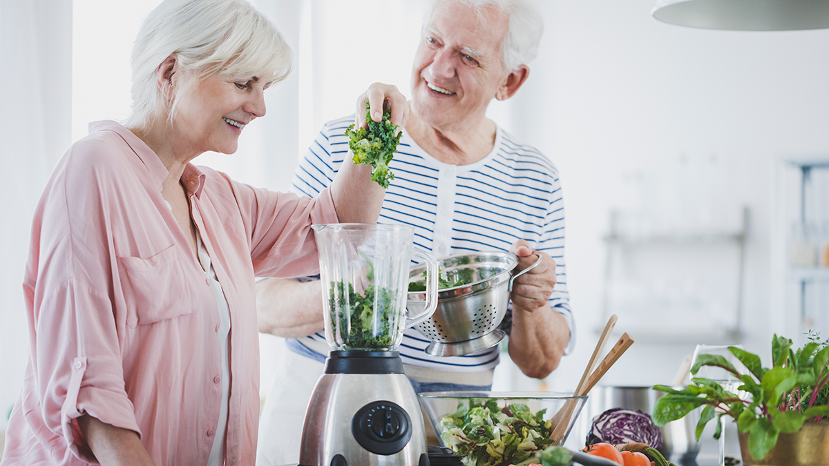 older couple using a blender at home