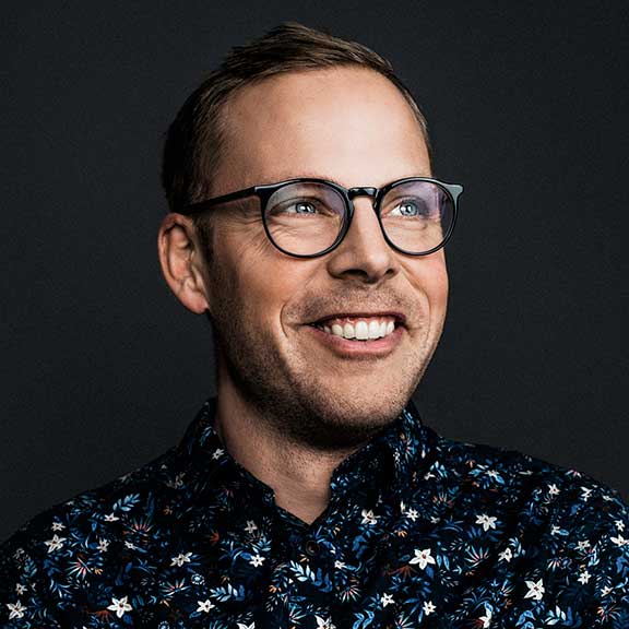 young man wearing glasses smiling sq