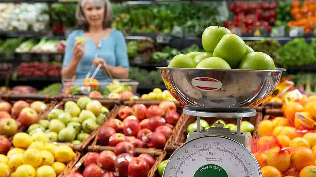 apples on scales at fruit and vegetable shop