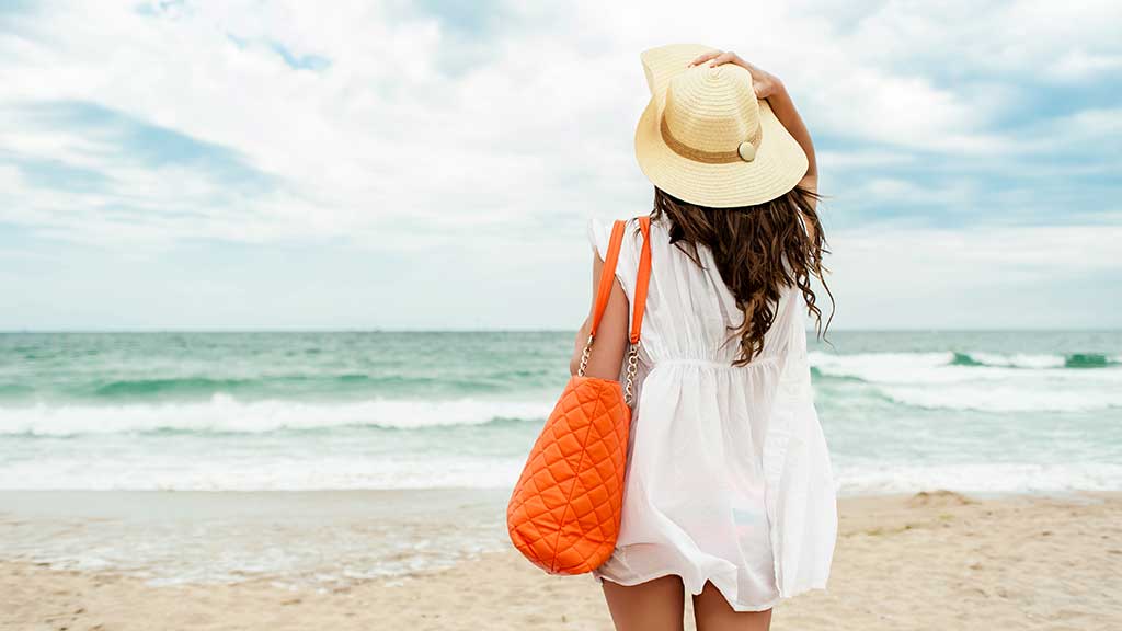 woman standing on beach looking out to sea