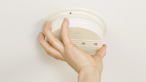 hand screwing in smoke alarm