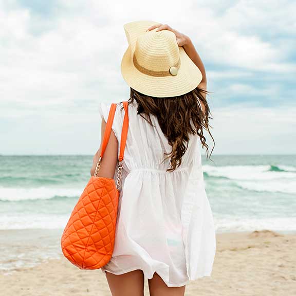 woman standing on beach looking out to sea square